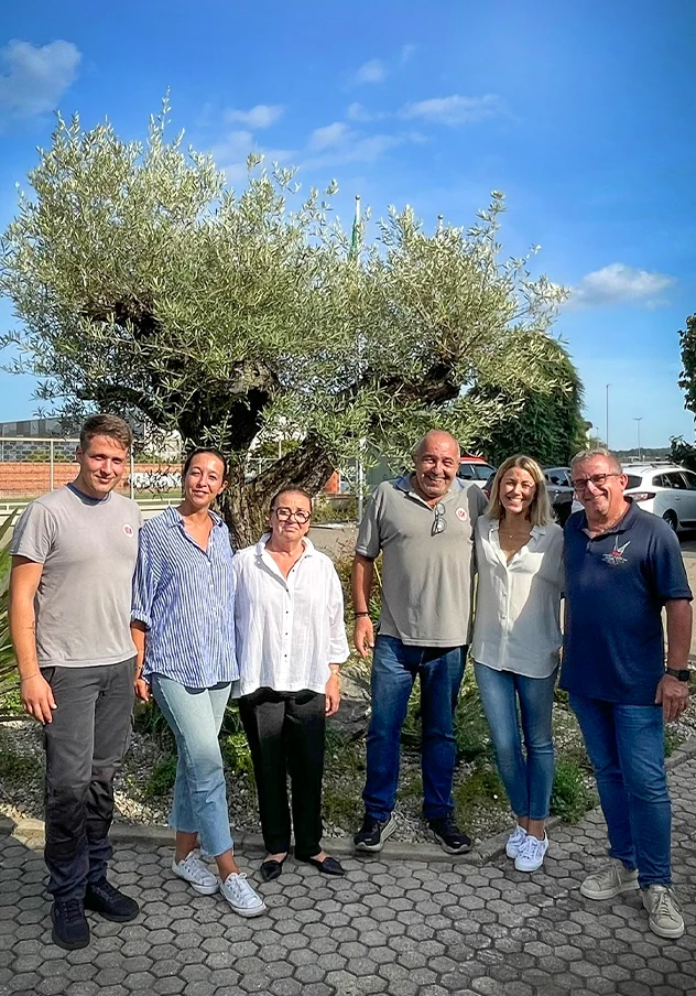 Foto della famiglia Zanolo davanti all'ulivo in ricordo del fondatore Piero Zanolo